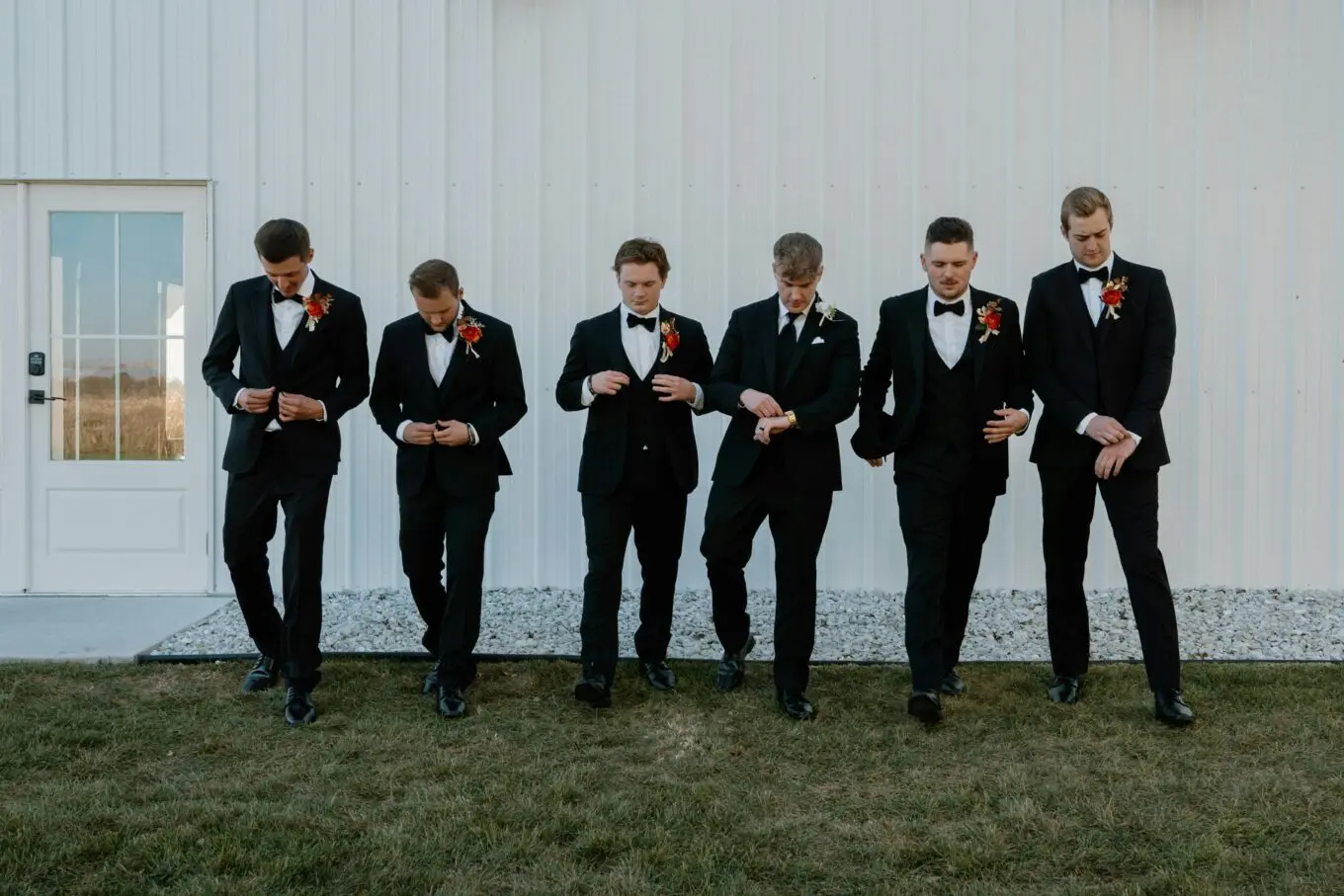 Boutonnieres by Occasion: A Sophisticated Guide to Personal Floral Accents 2 A group of groomsmen in black tuxedos prepare outside a wedding venue in Lake Geneva.